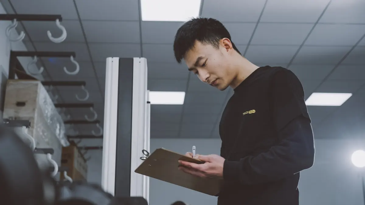 คนกำลังไล่เอกสารใบงานบนคลิปบอร์ดในห้องเก็บของ